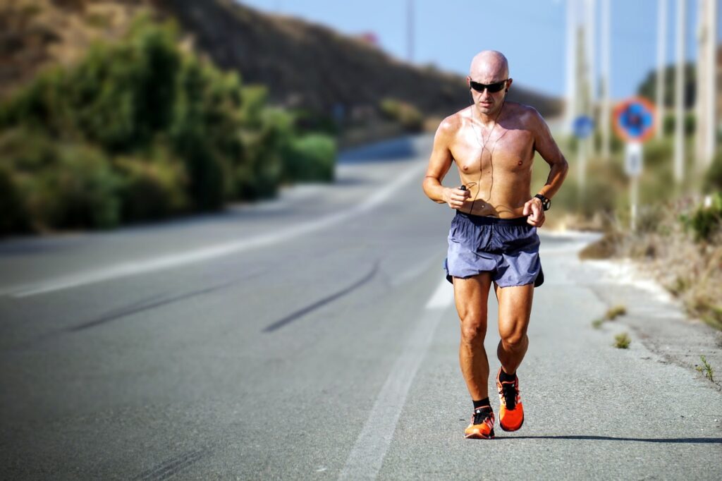 Man running on the streets for cardio training, dressed in half pants, sunglasses, headphones, and a watch, with vibrant orange shoes. The image captures the essence of outdoor fitness and beginner-friendly cardio exercises, showcasing a sunny day and a lively urban environment.