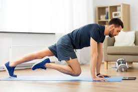 Man performing ground exercises on a light blue mat in a home environment, highlighting an introduction to fitness and beginner home workouts.